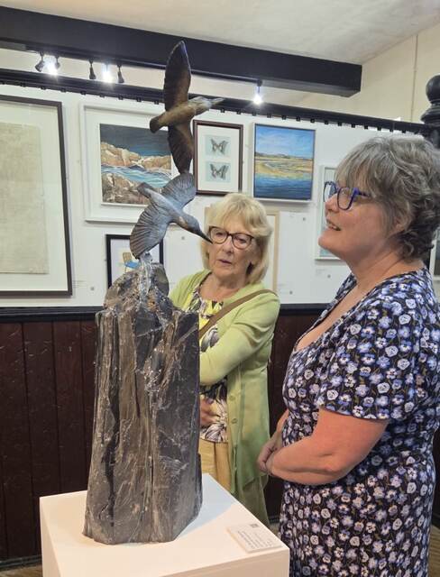 visitors take a look at Kingfisher Waterfall by Sculptress JOEL at Lamport Hall central Exhibition Untitled
