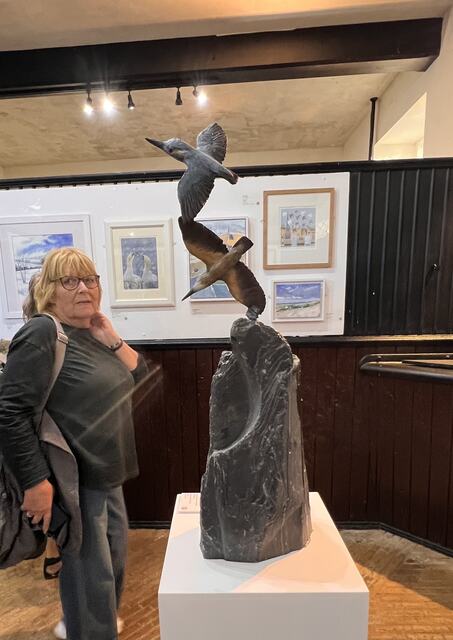 visitor takes a look at Kingfisher Waterfall by Sculptress JOEL at Lamport Hall central Exhibition Untitled