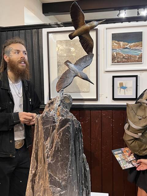 A visitor takes a look at Kingfisher Waterfall by Sculptress JOEL at Lamport Hall central Exhibition Untitled