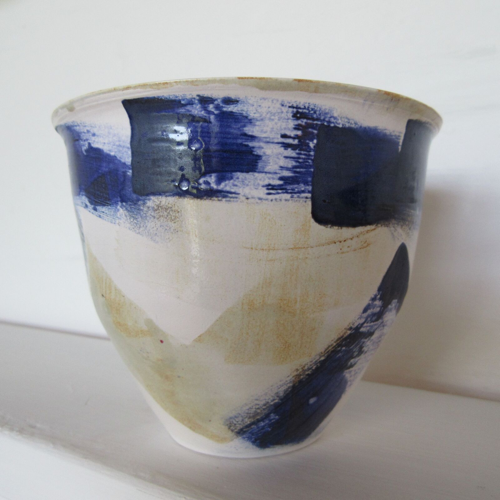 Transparent glaze over blue and brown brushed glazes