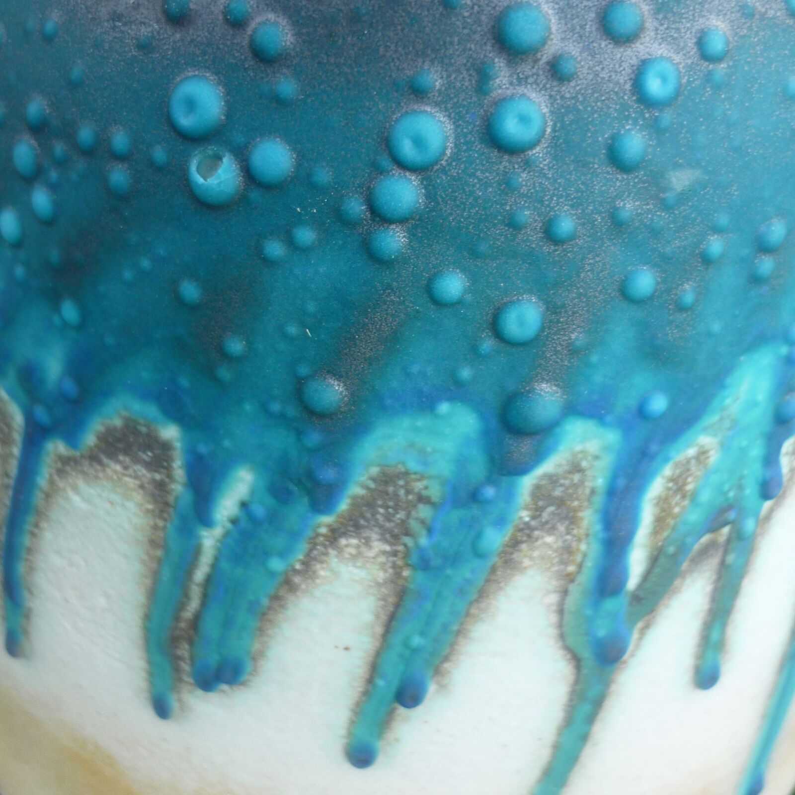 Close up of chemical reaction of two glazes on a ceramic pot