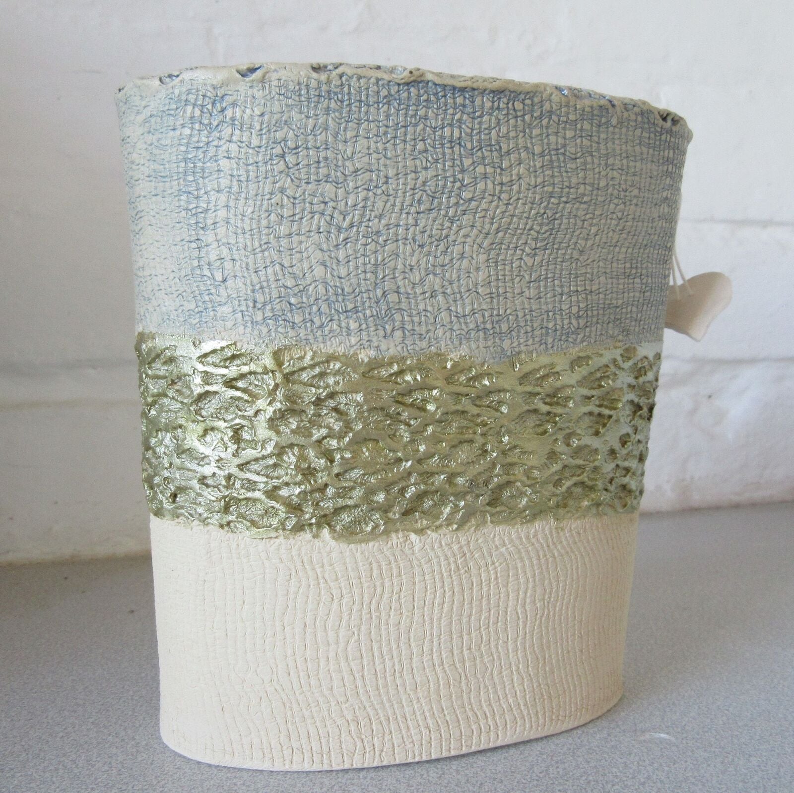 Mixed clays, internally glazed, outer surface pattern made by a fir cone and plastering fabric
