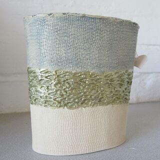 Mixed clays, internally glazed, outer surface pattern made by a fir cone and plastering fabric